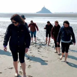 Les membres du cabinet Antarius Avocats marchent devant le Mont-ST-Michel